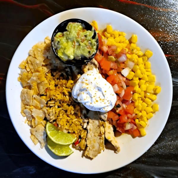 Broadway Grille's chicken fajita bowl with rice, corn, pico de gallo, guacamole, sour cream, and lime.