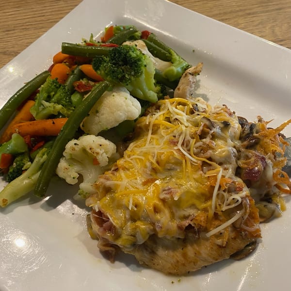 Cheesy chicken with mushrooms and a side of steamed green beans, carrots, broccoli, and cauliflower.